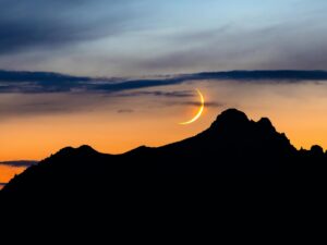 Crescent moon over horizon sillouette